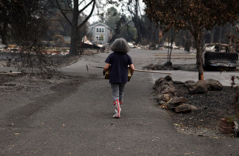 &copy; Reuters. Una mujer recupera objetos de entre los escombros de su casa destruida tras el paso de un incendio forestal por la zona en Talent, Oregón, Estados Unidos, 21 de septiembre de 2020. REUTERS/Jim Urquhart/Foto de archivo