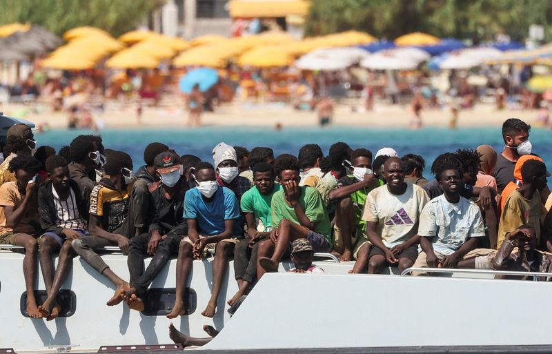 &copy; Reuters. مهاجرون يصلون على متن سفينة تابعة لخفر السواحل الإيطالي بعد إنقاذهم في البحر على جزيرة لامبيدوزا الإيطالية يوم الجمعة. تصوير: يارا ناردي - ر