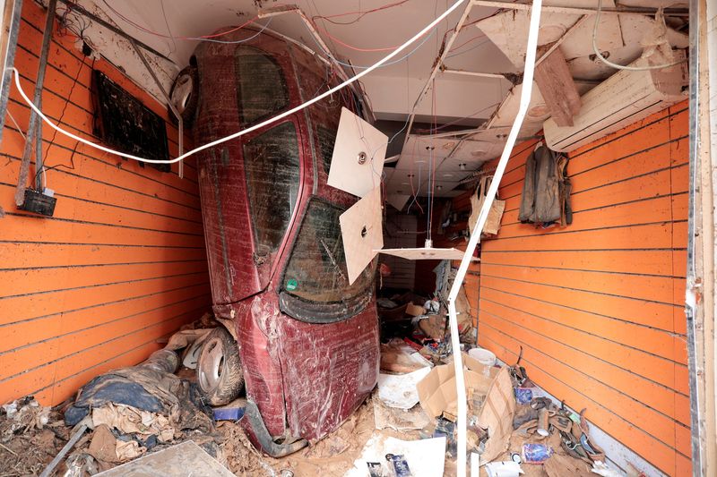 © Reuters. An upturned car swept by floodwater is seen inside a shop in the aftermath of the floods in Derna, Libya September 16, 2023. REUTERS/Zohra Bensemra