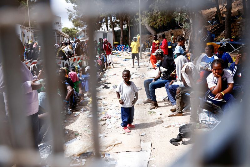 © Reuters. A child looks on as migrants are seen inside the hotspot, on the Sicilian island of Lampedusa, Italy, September 16, 2023. REUTERS/Yara Nardi 