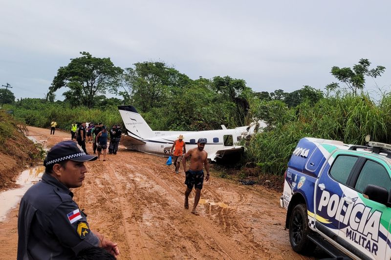 © Reuters. أشخاص يتفحصون طائرة تحطمت في إقليم بارسيلوس بولاية الأمازون في البرازيل وأسفرت عن مقتل 14 شخصا يوم السبت. تصوير: ويلينجتون ميلو - رويترز. يحظر بيع الصورة أو الاحتفاظ بها في أرشيف.