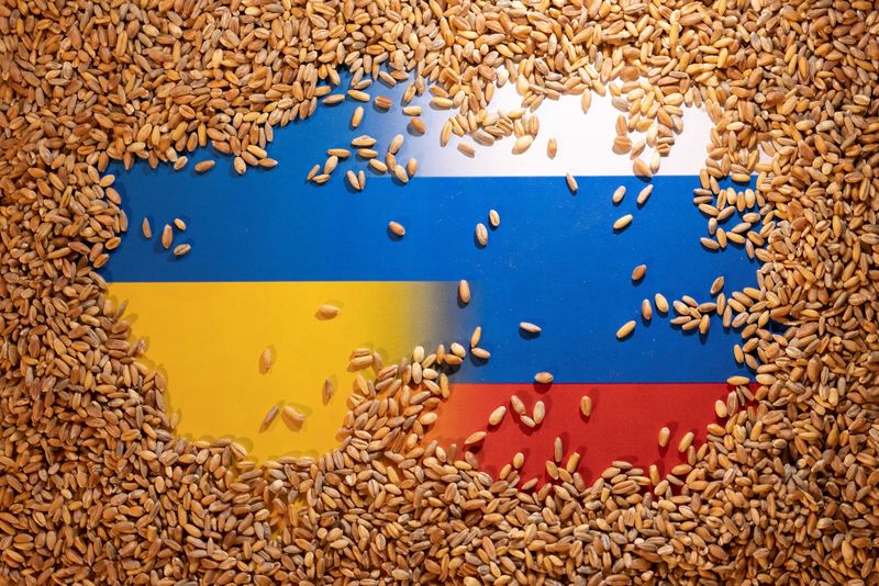 © Reuters. Grain is placed on Ukrainian and Russian flags in this picture illustration taken May 9, 2022. REUTERS/Dado Ruvic/Illustration/file photo