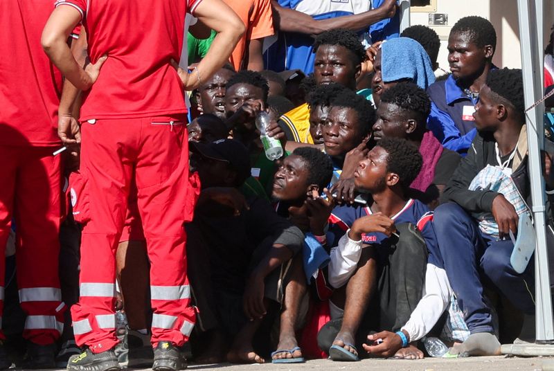 &copy; Reuters. Los inmigrantes se reúnen en el hotspot, un centro de recepción para inmigrantes, antes de la visita de la presidenta de la Comisión Europea, Ursula von der Leyen, y la primera ministra italiana, Giorgia Meloni, a la isla siciliana de Lampedusa, Italia