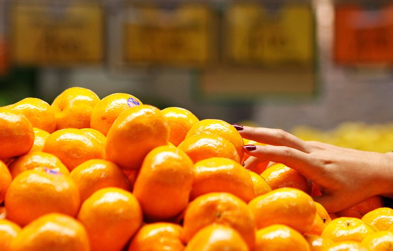 &copy; Reuters. FILE PHOTO: A woman picks up some mandarin oranges at a fruits shop in Sydney June 7, 2011.REUTERS/Daniel Munoz/File Photo