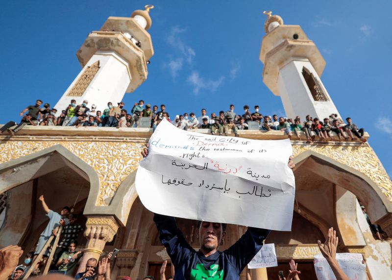 &copy; Reuters. Las personas que sobrevivieron a la tormenta mortal que azotó Libia, protestan frente a la mezquita de Al Sahaba contra el gobierno en Derna, Libia, el 18 de septiembre de 2023. El cartel dice: "La triste ciudad de Derna exige sus derechos". REUTERS/Zohr