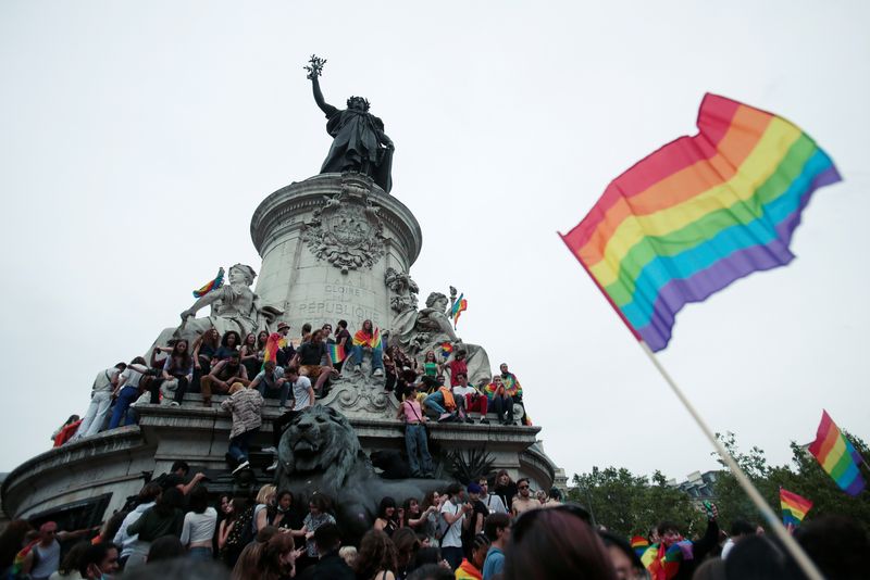 &copy; Reuters. Des manifestants portant des drapeaux arc-en-ciel et des pancartes sont assis sur un monument lors d'une marche des fiertés LGBTQ, sur la place de la République à Paris, en France. /Photo d'archives/REUTERS/Sarah Meyssonnier