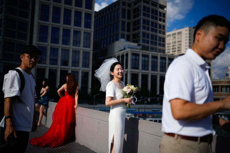 © Reuters. Couples prepare to get their photo taken during a wedding photography shoot on a street, in Shanghai, China September 6, 2023. REUTERS/Aly Song