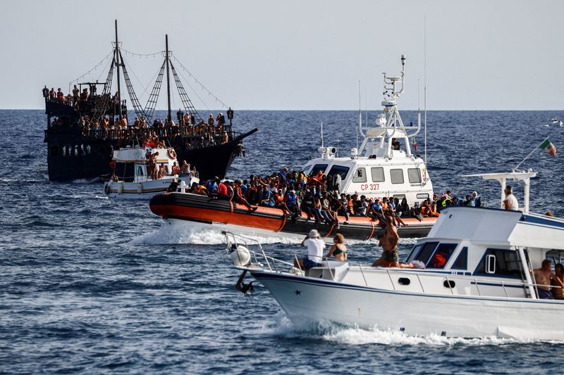 &copy; Reuters. An Italian Coast Guard vessel carrying migrants rescued at sea passes between tourist boats, on Sicilian island of Lampedusa, Italy, September 18, 2023. REUTERS/Yara Nardi