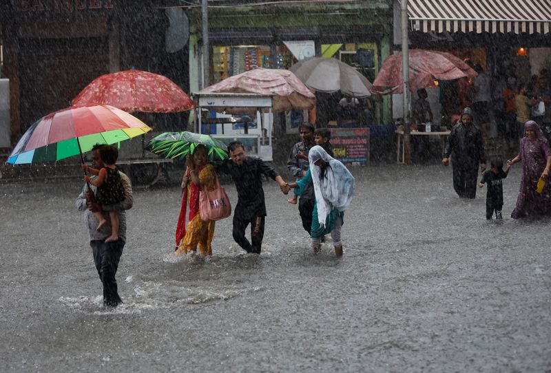 &copy; Reuters. La gente camina por una calle inundada en medio de fuertes lluvias en Ahmedabad, India. 17 de septiembre, 2023. REUTERS/Amit Dave
