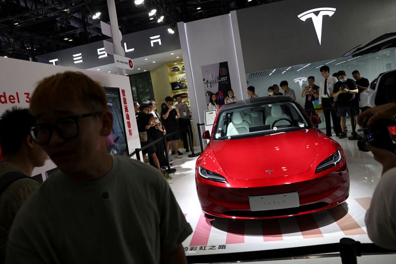 © Reuters. FILE PHOTO: Visitors stand outside barriers surrounding Tesla's new Model 3 sedan displayed at the China International Fair for Trade in Services (CIFTIS) in Beijing, China September 2, 2023. REUTERS/Florence Lo/File Photo