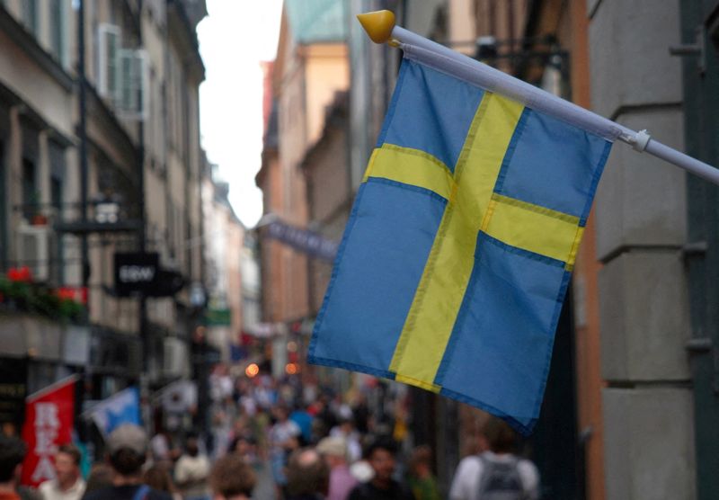 &copy; Reuters. علم السويد يرفرف خارج متجر في شارع مزدحم بوسط المدينة القديمة بستوكهولم في 14 يوليو تموز 2023 . تصوير : توم ليتل - رويترز .  