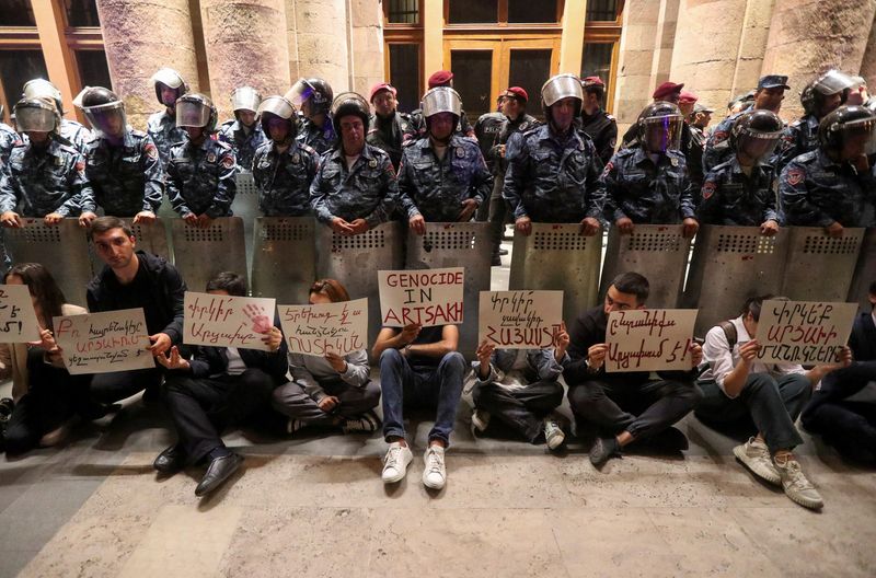 © Reuters. Protesters sit in front of law enforcement officers near the government building during a rally to support ethnic Armenians in Nagorno-Karabakh following Azerbaijani armed forces' offensive operation executed in the region, in Yerevan, Armenia, September 20, 2023. REUTERS/Irakli Gedenidze