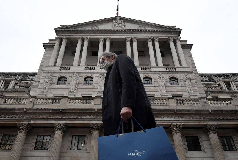 &copy; Reuters. FILE PHOTO: A man wearing a protective face mask walks past the Bank of England (BoE) in London, Britain, December 16, 2021. REUTERS/Toby Melville/File Photo