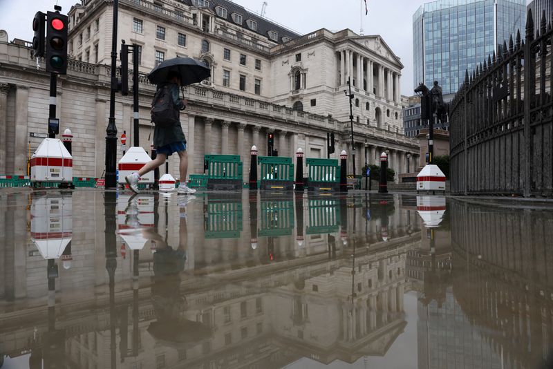 &copy; Reuters. FILE PHOTO: A pedestrian carrying an umbrella walks near the Bank of England in the City of London, Britain, July 30, 2023. REUTERS/Hollie Adams/File Photo