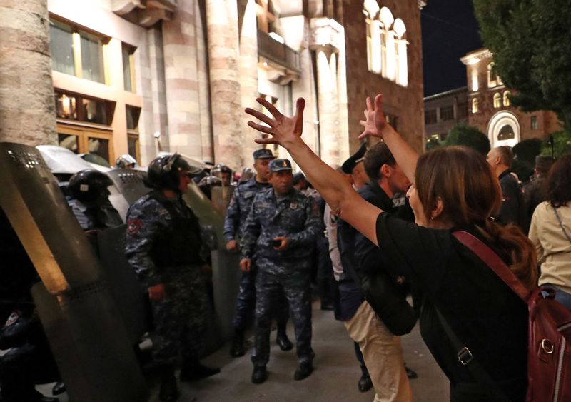 © Reuters. A protester reacts next to law enforcement officers who stand guard outside the government building during a rally to demand the resignation of Armenian Prime Minister Nikol Pashinyan following Nagorno-Karabakh surrender, in Yerevan, Armenia, September 21, 2023. Hayk Baghdasaryan/Photolure via REUTERS