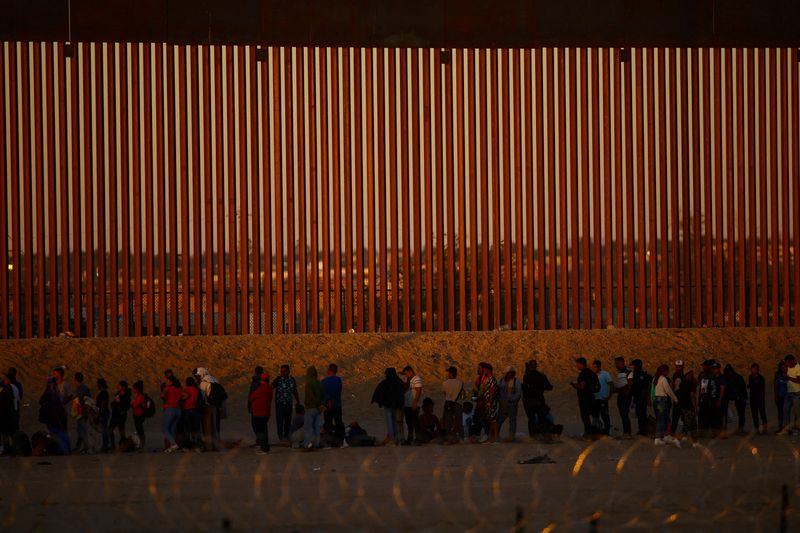 &copy; Reuters. FILE PHOTO: Migrants seeking asylum in the United States gather near a border wall on the banks of the Rio Bravo River, on the border between the U.S. and Mexico, as seen from Ciudad Juarez, Mexico September 19, 2023. REUTERS/Jose Luis Gonzalez/File Photo