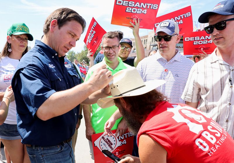 &copy; Reuters. FILE PHOTO: Republican U.S. presidential candidate and Florida Governor Ron DeSantis signs a supporter's hat, as he campaigns at the Iowa State Fair in Des Moines, Iowa, U.S. August 12, 2023. REUTERS/Scott Morgan/File Photo