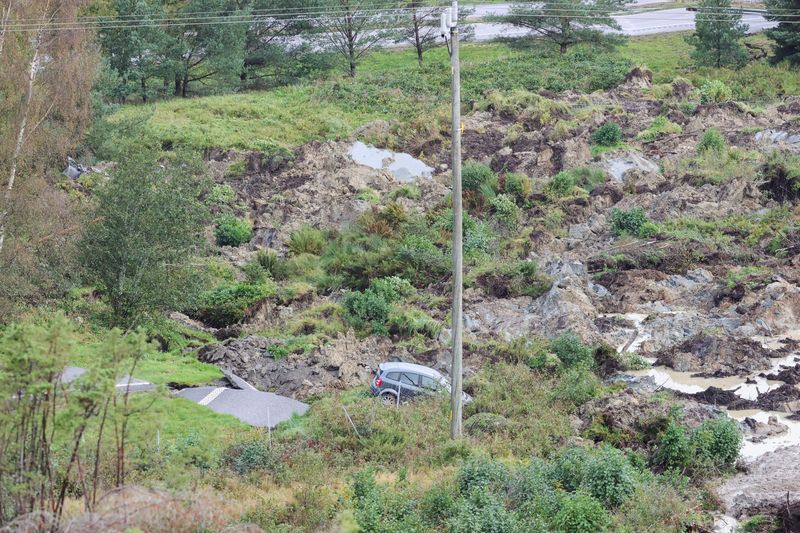 &copy; Reuters. سيارة وجانب من الانهيار الارضي في طريق سريع بالقرب من ستينوسوند في السويد يوم السبت. صورة لرويترز من وكالة أنباء تي.تي. (حصلت رويترز على هذه ا