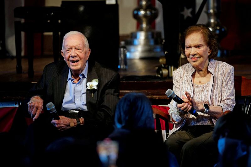 &copy; Reuters. FILE PHOTO: Former U.S. President Jimmy Carter and his wife, former first lady Rosalynn Carter sit together during a reception to celebrate their 75th wedding anniversary in Plains, Georgia, U.S. July 10, 2021. John Bazemore/Pool via REUTERS/File Photo