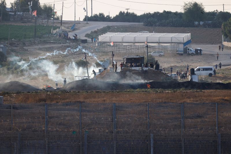 © Reuters. جنود إسرائيليون ومتظاهرون فلسطينيون يشتبكون بالقرب من الحدود بين إسرائيل وغزة يوم السبت. تصوير: عامير كوهين - رويترز.