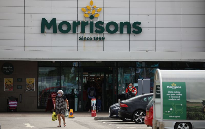© Reuters. FILE PHOTO: A customer carries a shopping bag outside a Morrisons supermarket in New Brighton, Britain, July 5, 2021. REUTERS/Phil Noble