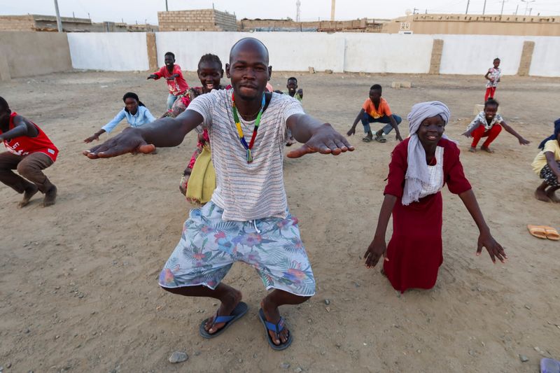 &copy; Reuters. جنرال كيدي أحد أعضاء  فرقة "صوت جبال النوبة" يدرب أطفالا سودانيين خلال عرض موسيقي تقدمه الفرقة في بورتسودان يوم الثلاثاء . تصوير : الطيب صديق -
