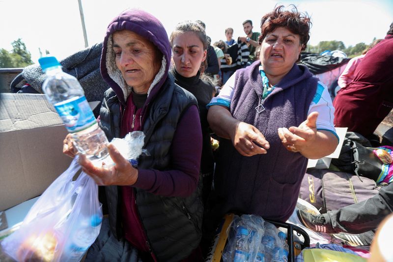 &copy; Reuters. Emma (L) from the village of Vaghuhas in the Martakert Province, who didn't give her family name, and other refugees from Nagorno-Karabakh region speak with a reporter in the back of a truck upon their arrival in the border village of Kornidzor, Armenia, 