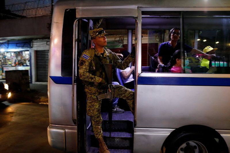 © Reuters. A soldier guards a bus during rush hour in an area historically dominated by a gang, in downtown San Salvador, El Salvador September 26, 2023. REUTERS/Jose Cabezas