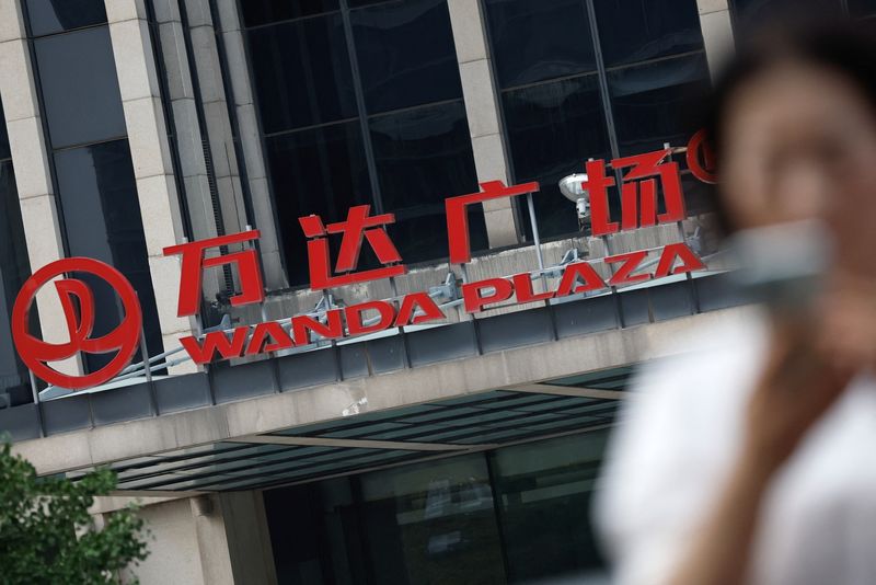 © Reuters. FILE PHOTO: A person walks past the headquarters of Dalian Wanda Group, in Beijing's Central Business District (CBD), China August 8, 2023. REUTERS/Tingshu Wang