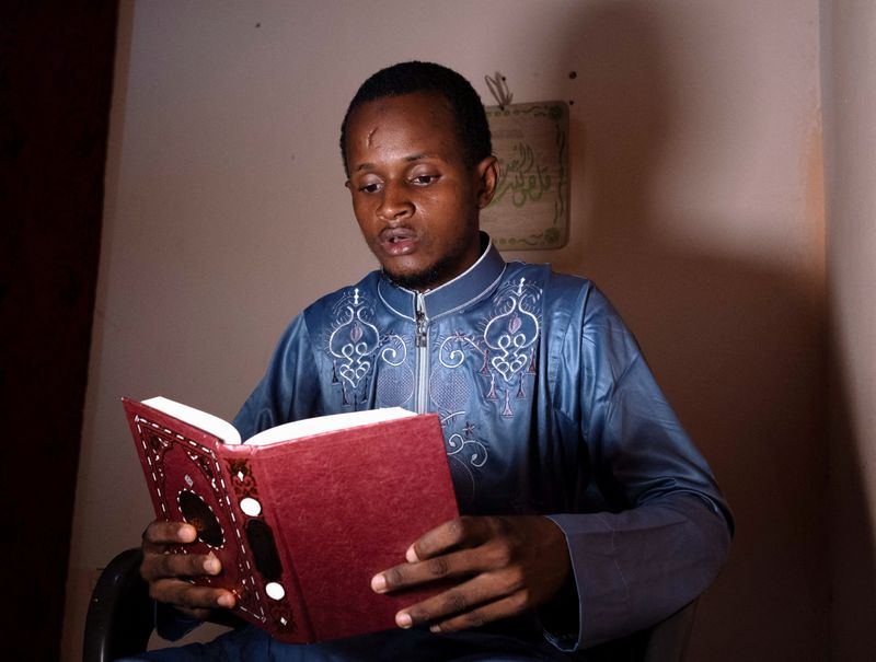 &copy; Reuters. الطالب الغيني مامادو سافايو باري البالغ 25 عاما يقرأ القرآن في منزله الجديد في منطقة المرج شرق القاهرة بعد الحصول على منحة للدراسة بجامعة ال