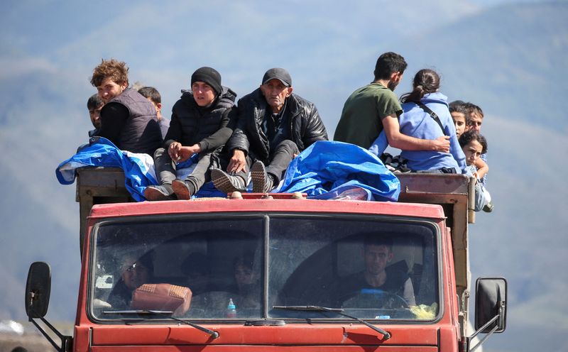 © Reuters. لاجئون من منطقة ناجورنو قرة باغ يستقلون شاحنة لدى وصولهم إلى قرية حدودية في أرمينيا يوم الأربعاء. تصوير: إراكلي جديندج - رويترز.