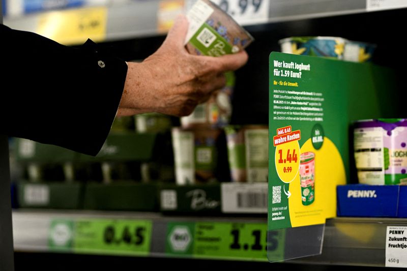 &copy; Reuters. FILE PHOTO: A person holds a product near the price tag, with reference to the Europe-wide "true costs" campaign week by the discount supermarket Penny, in which nine selected products are given the calculated "real price" as the sales price, under consid