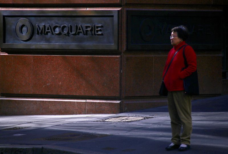 &copy; Reuters. FILE PHOTO: A pedestrian stands near the logo of Australia's biggest investment bank Macquarie Group Ltd which adorns a wall on the outside of their Sydney office headquarters in central Sydney, Australia, July 18, 2017. REUTERS/David Gray/File Photo
