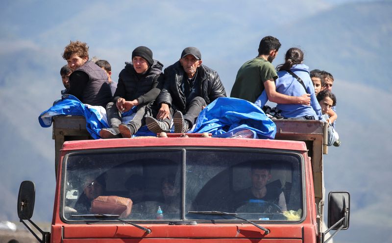 &copy; Reuters. Refugees from Nagorno-Karabakh region ride in a truck upon their arrival at the border village of Kornidzor, Armenia, September 27, 2023. REUTERS/Irakli Gedenidze   