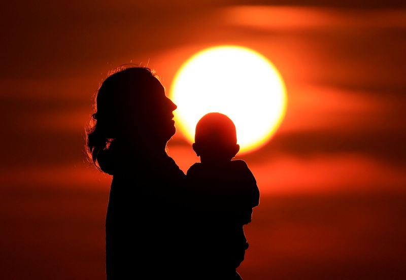 &copy; Reuters. Une mère et son bébé lors coucher de soleil sur la plage de Calais. /Photo prise le 16 août 2023/REUTERS/Pascal Rossignol