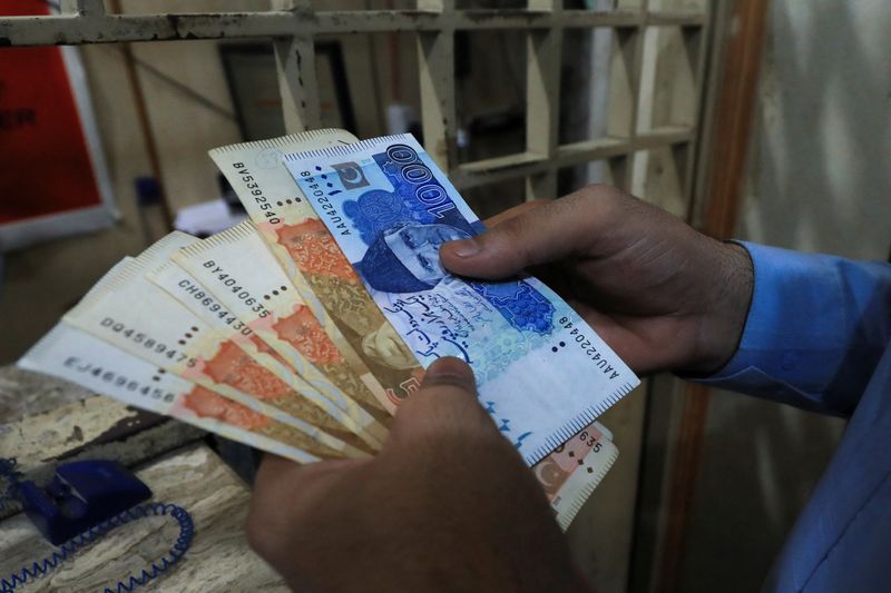 &copy; Reuters. FILE PHOTO: A man counts Pakistani rupee notes at a currency exchange shop in Peshawar, Pakistan September 12, 2023. REUTERS/Fayaz Aziz/File Photo