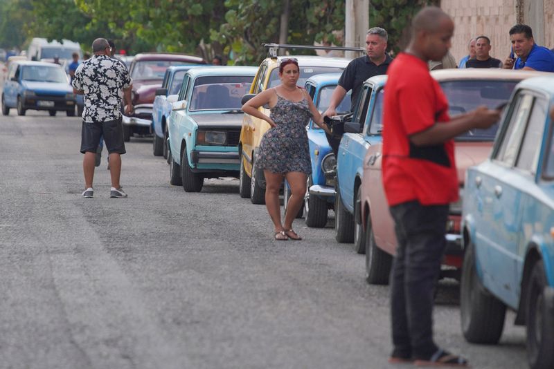 &copy; Reuters. FOTO DE ARCHIVO: La gente espera en fila la llegada de un camión cisterna de combustible en La Habana, Cuba. 14 de abril, 2023. REUTERS/Alexandre Meneghini/Archivo