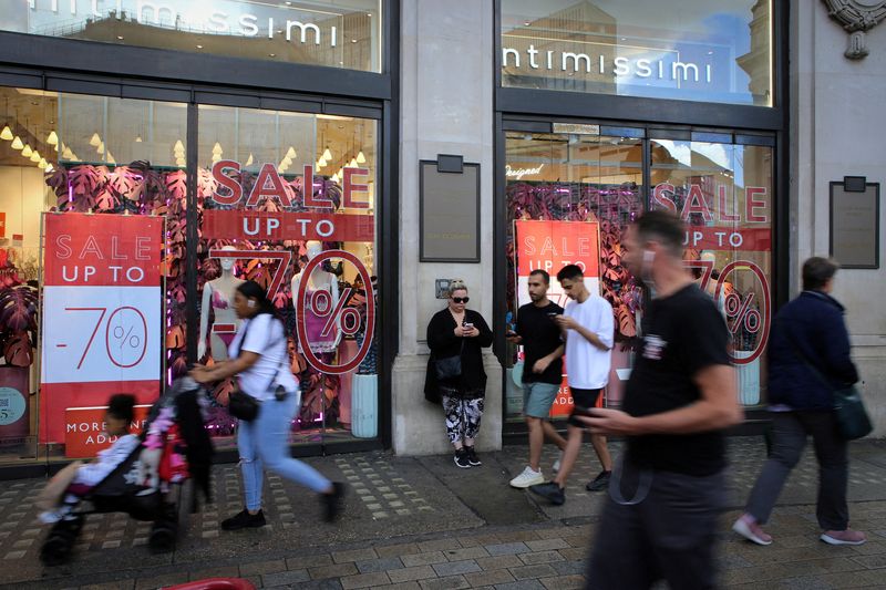 © Reuters. FILE PHOTO: Shoppers walk past sale signs on Oxford Street, as Britain struggles with the highest inflation rate among the world's big rich economies, London, Britain, 17 July 2023. REUTERS/Rachel Adams/File Photo