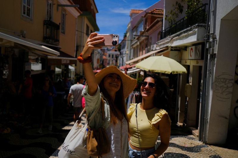 &copy; Reuters. FILE PHOTO: Tourists take a picture on a street in Cascais, Portugal, June 6, 2022. Picture taken June 6, 2022. REUTERS/Pedro Nunes/File Photo