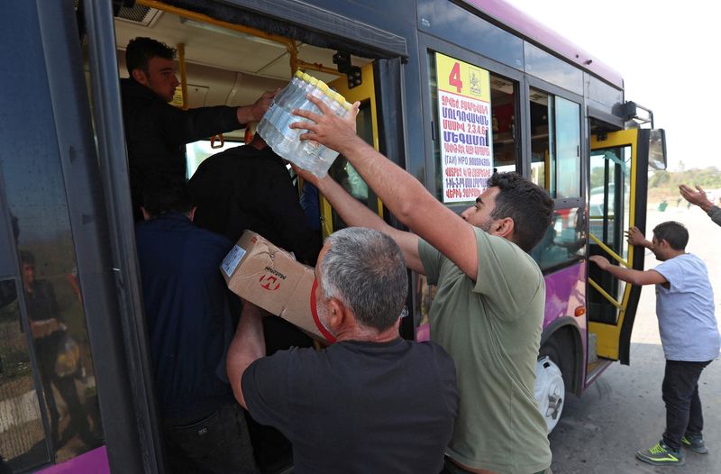 &copy; Reuters. Voluntarios dan agua y comida a refugiados de la región de Nagorno-Karabaj que llegan a la aldea fronteriza de Kornidzor, Armenia, el 29 de septiembre de 2023. REUTERS/Irakli Gedenidze