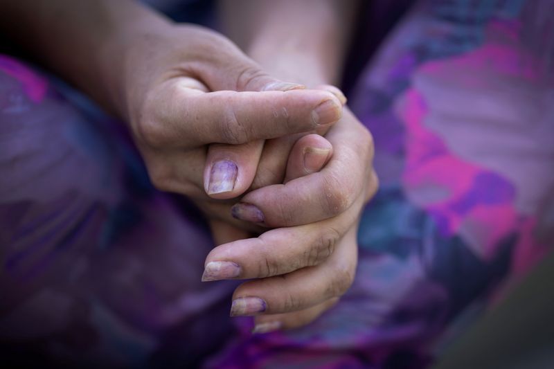 © Reuters. An Ecuadorean migrant clasps her hands while recalling how she was held kidnapped and sexually trafficked near the U.S.-Mexico border, as she speaks with reporters in New Jersey, U.S., on August 18, 2023. REUTERS/Maye-E Wong