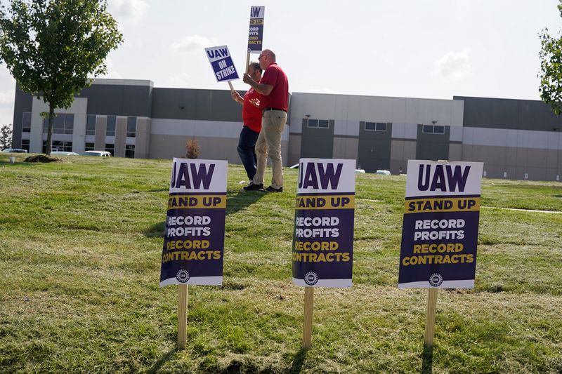 &copy; Reuters. Des grévistes de l'UAW dressent un piquet de grève devant une usine de transformation de GM à Burton, dans le Michigan, aux Etats-Unis. /Photo prise le 22 septembre 2023/REUTERS/Dieu-Nalio Chery