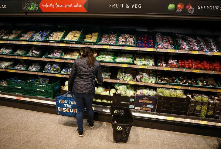 © Reuters. FILE PHOTO: A shopper looks at fruit and vegetables inside an ALDI supermarket near Altrincham, Britain, February 20, 2023. REUTERS/Phil Noble/File Photo