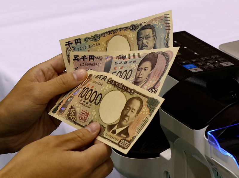 © Reuters. FILE PHOTO: A worker holds samples of new Japanese yen banknotes at a factory of the National Printing Bureau producing Bank of Japan notes at a media event about the new notes scheduled to be introduced in 2024, in Tokyo, Japan, November 21, 2022. REUTERS/Kim Kyung-Hoon/File Photo