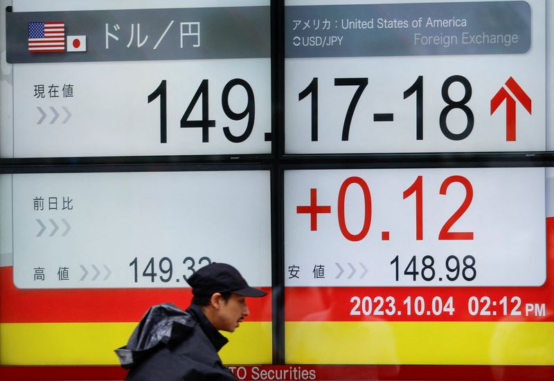 © Reuters. A man walks past an electric monitor displaying the Japanese yen exchange rate against the U.S. dollar outside a brokerage in Tokyo, Japan October 4, 2023. REUTERS/Issei Kato