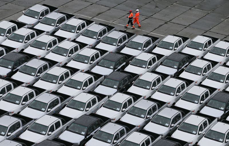 &copy; Reuters. Workers walk past new Chinese cars unloaded from a ship at a commercial port in Vladivostok, Russia August 25, 2023. REUTERS/Tatiana Meel