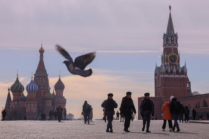 © Reuters. People, including Russian law enforcement officers, walk near St. Basil's Cathedral and the Kremlin's Spasskaya Tower in Red Square in central Moscow, Russia, March 20, 2023. REUTERS/Evgenia Novozhenina/files