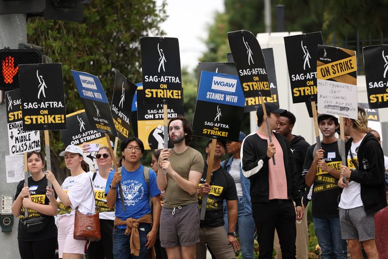 &copy; Reuters. FILE PHOTO:SAG-AFTRA members hold placards as they walk the picket line during their ongoing strike outside Sony Studios in Culver City, California, U.S. September 29, 2023. REUTERS/Mario Anzuoni/File Photo
