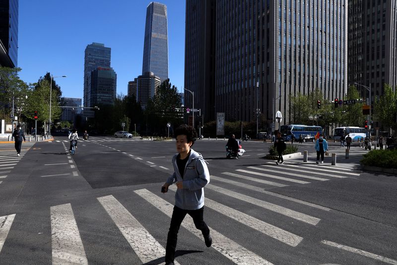 &copy; Reuters. A man walks past a street at Beijing's Central Business District (CBD) during morning rush hour, in Beijing, China April 18, 2023. REUTERS/Tingshu Wang/File photo