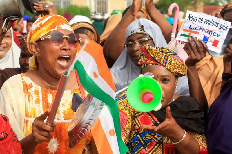 &copy; Reuters. Photo d'archives: Une personne tient un papier qui dit « nous ne voulons plus de France », alors que les femmes nigériennes mainfestent en soutien des putschistes devant le quartier général de l'armée française, à Niamey, au Niger. /Photo prise le
